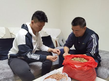 高二8班王绍文假期活动照片：和爸爸剥爷爷种的花生。.JPG