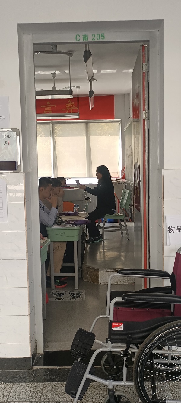 丁老师坐着轮椅去上课.jpg